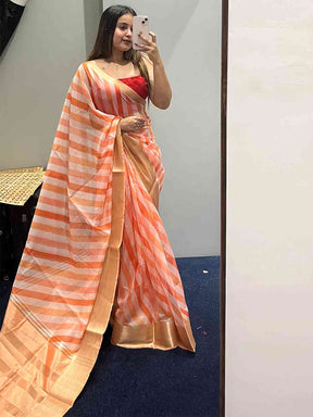 Party wear organza saree with orange leheriya pattern and red blouse.