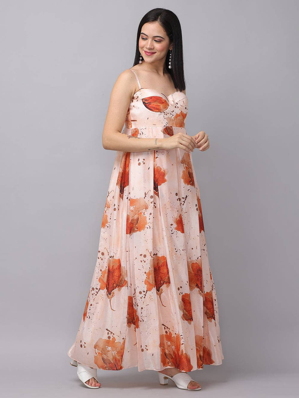 Model posing in peach color corset dress, floral pattern.