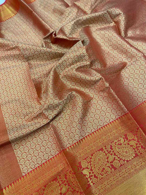 Close-up of gold zari Kanjivaaram silk saree fabric with floral design.