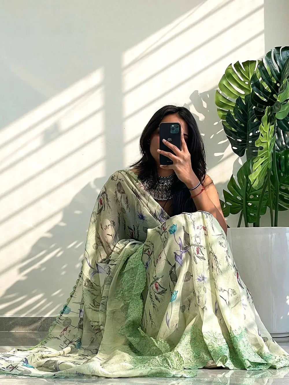 Chiffon satin saree with floral patterns and detailed green border.