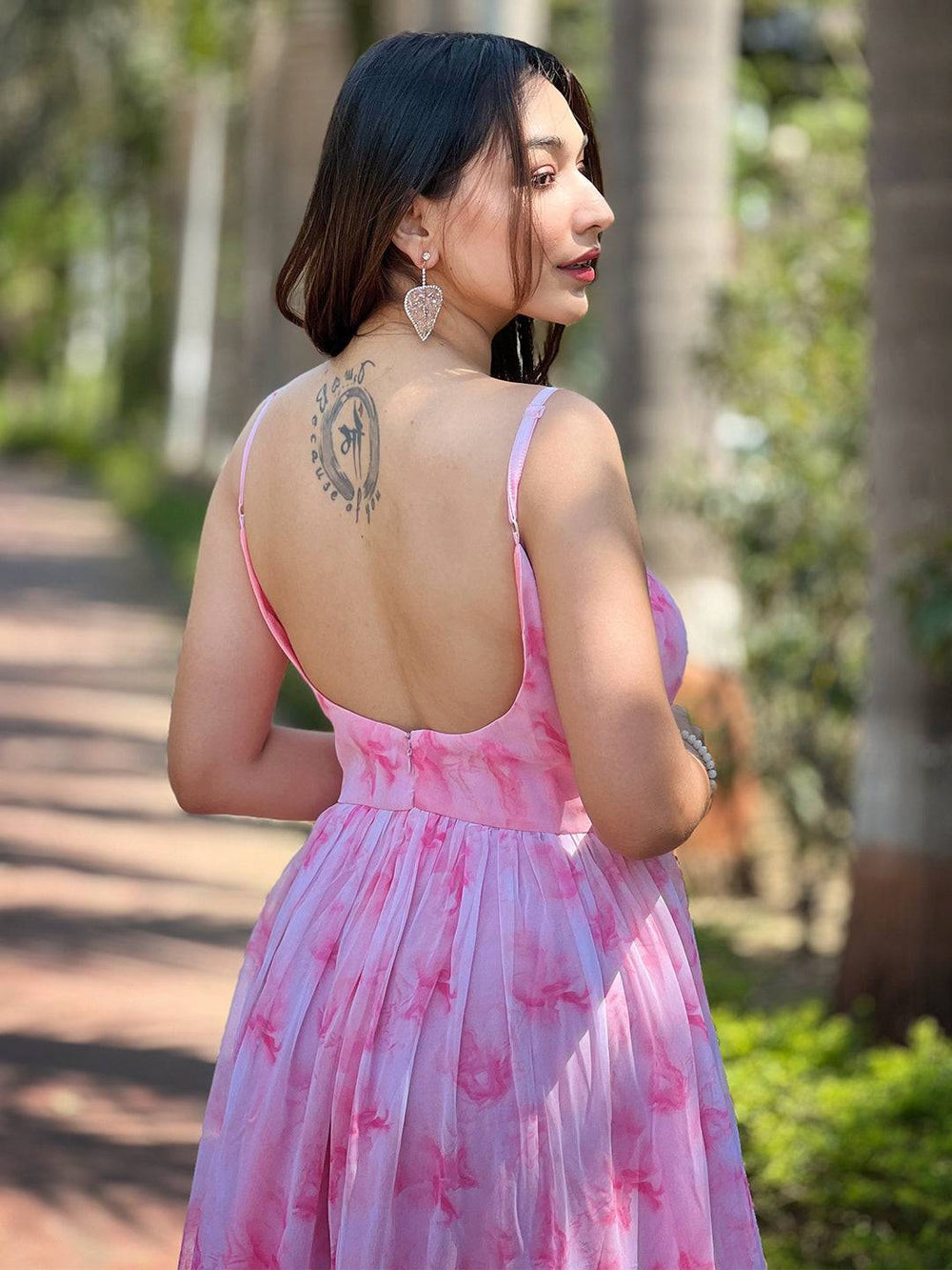 Model displaying back tattoo in blush pink batik dress