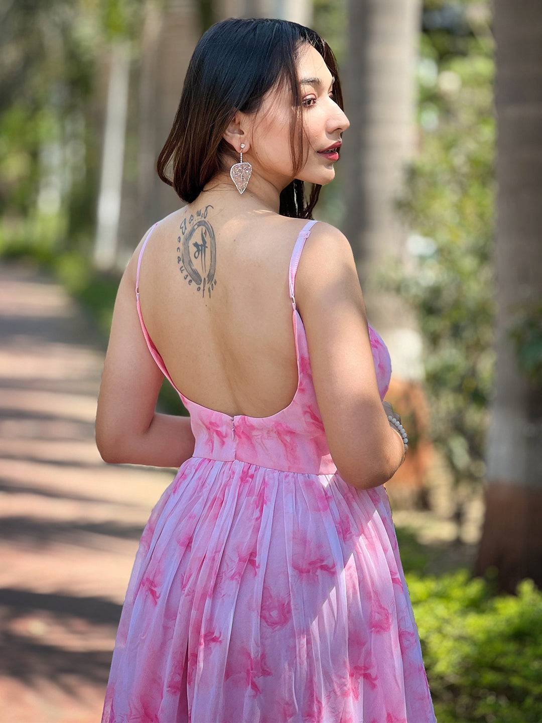 Model displaying back tattoo in blush pink batik dress