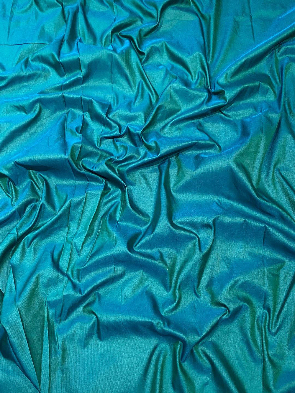 Close-up of green soft silk fabric with smooth texture
