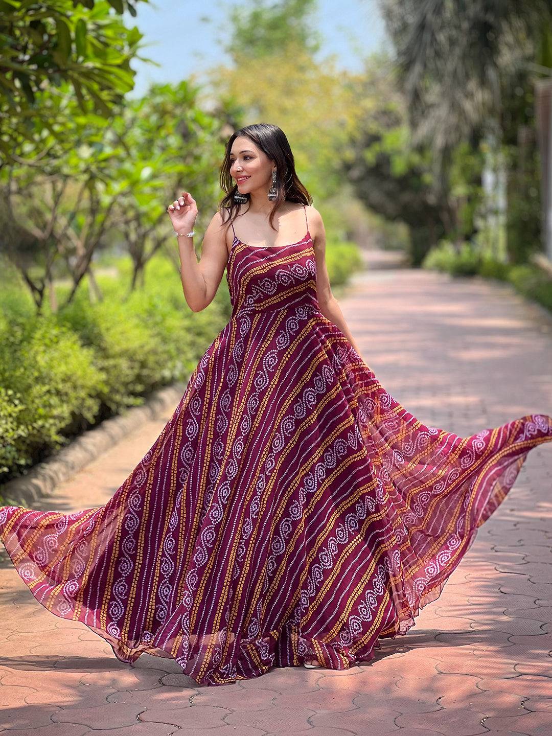 Woman twirling in Wine Bandhej Printed Dress on path