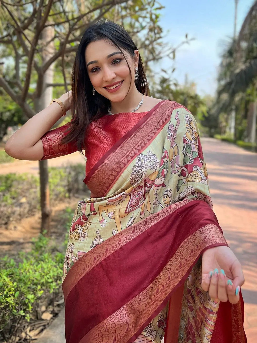 Woman showcasing red Banarasi silk saree with artistic design