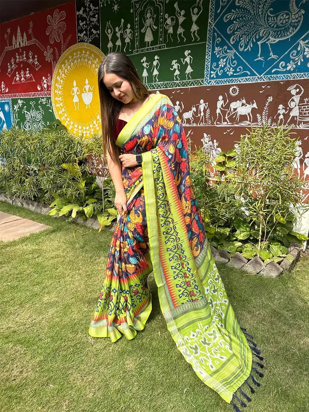 Floral Ikkat saree with vibrant colors in front of mural