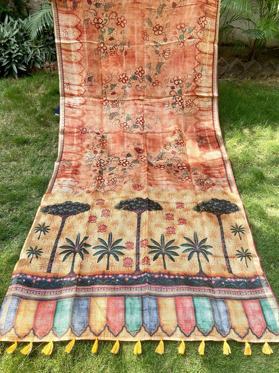 Orange Kota Doriya silk saree with floral and tree motifs spread out.