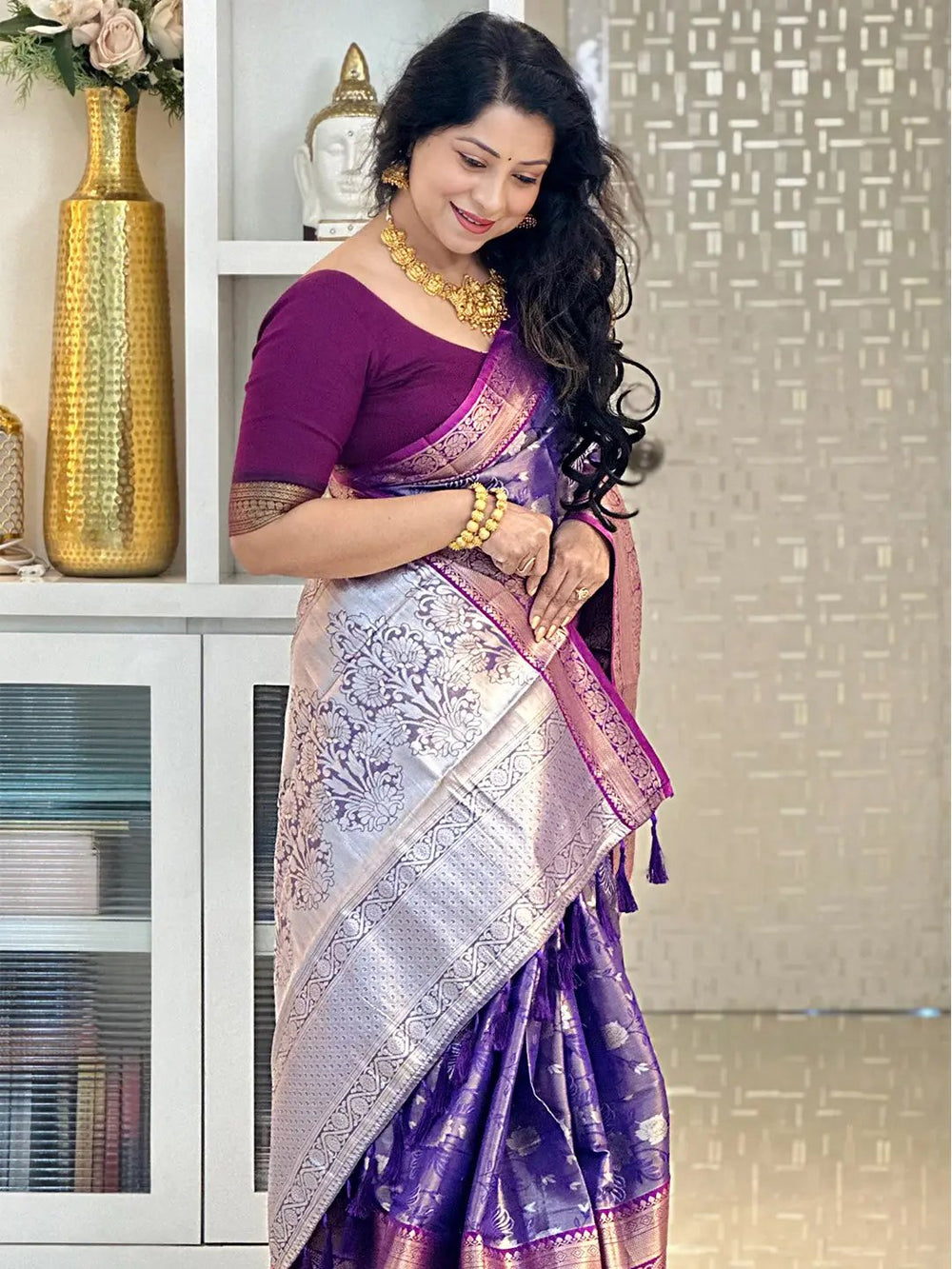 Woman elegantly wearing purple tissue silk saree