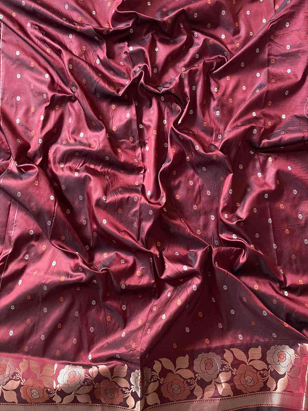 Close-up of wine Banarasi silk saree with floral zari border
