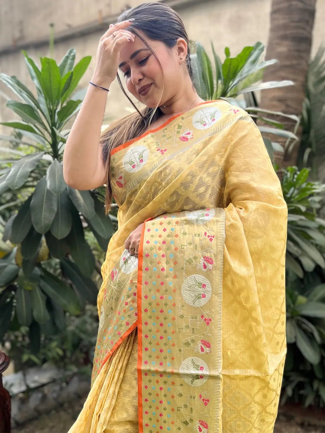 Woman in yellow Kota Doria silk saree with Minakari Patola design