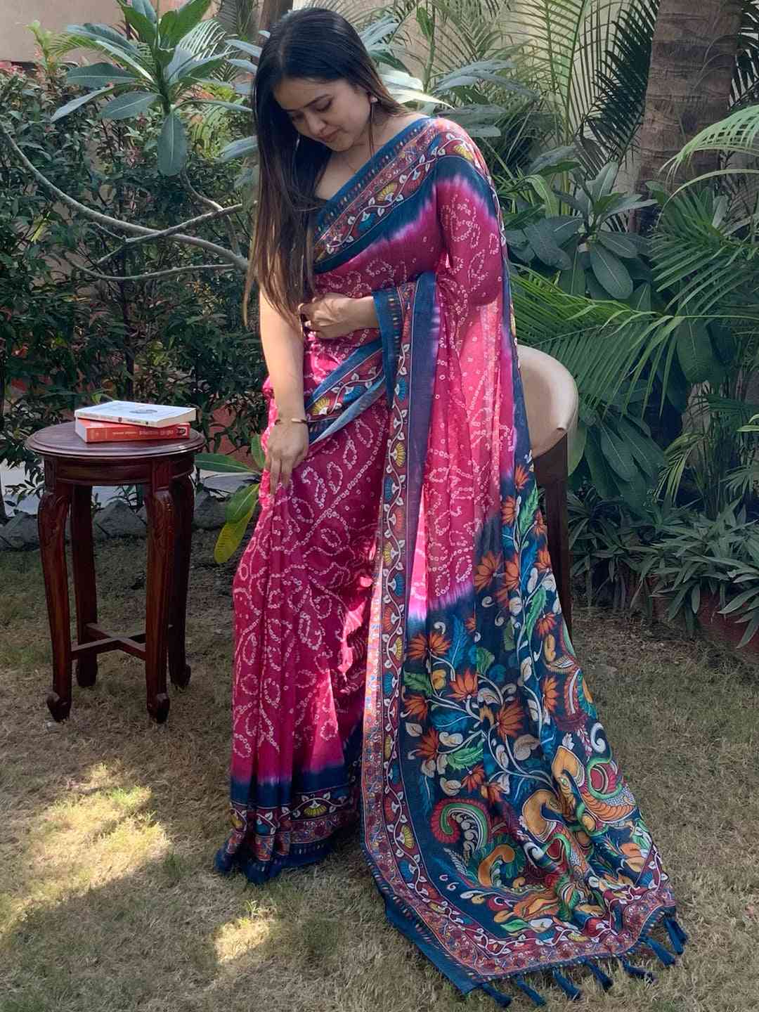 Woman showcasing pink Bandhej Kalamkari Saree in garden