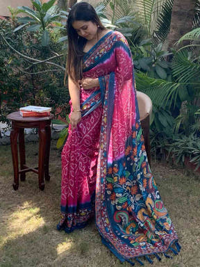 Woman showcasing pink Bandhej Kalamkari Saree in garden