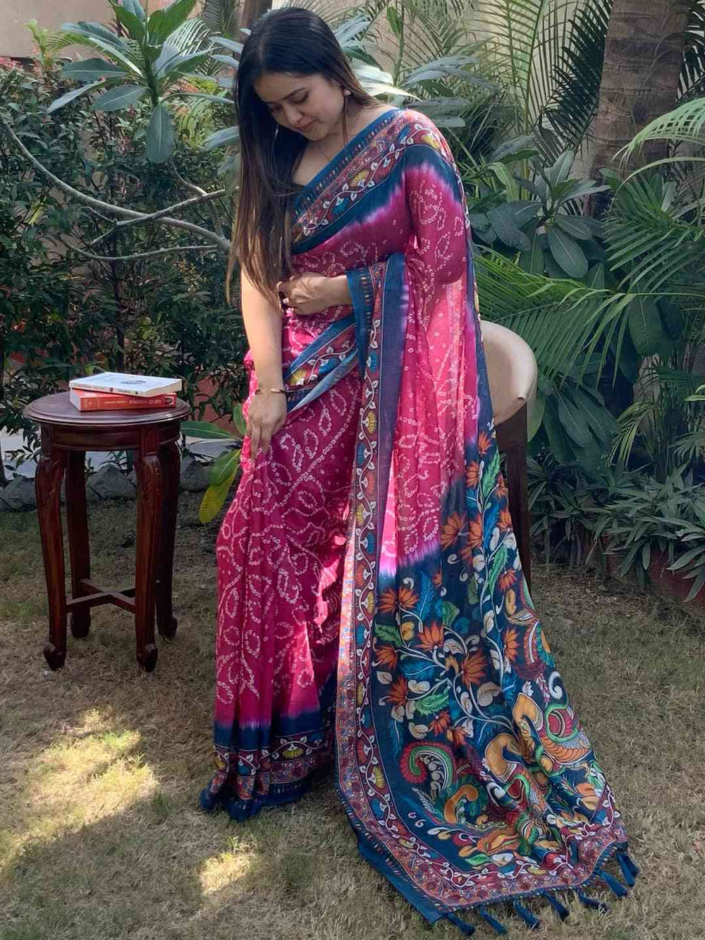 Woman showcasing pink Bandhej Kalamkari Saree in garden