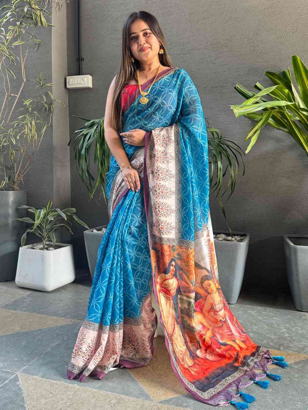 Model wearing blue saree with kalamkari print, standing pose