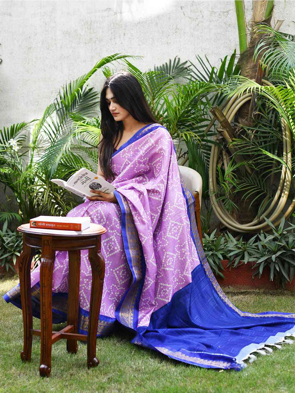 Woman in soft silk Bandhej saree with Kanjivaaram border, reading.