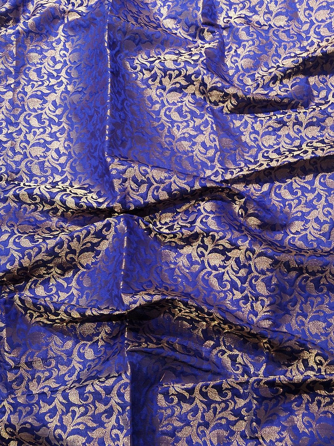 Close-up of blue brocade fabric with gold zari pattern