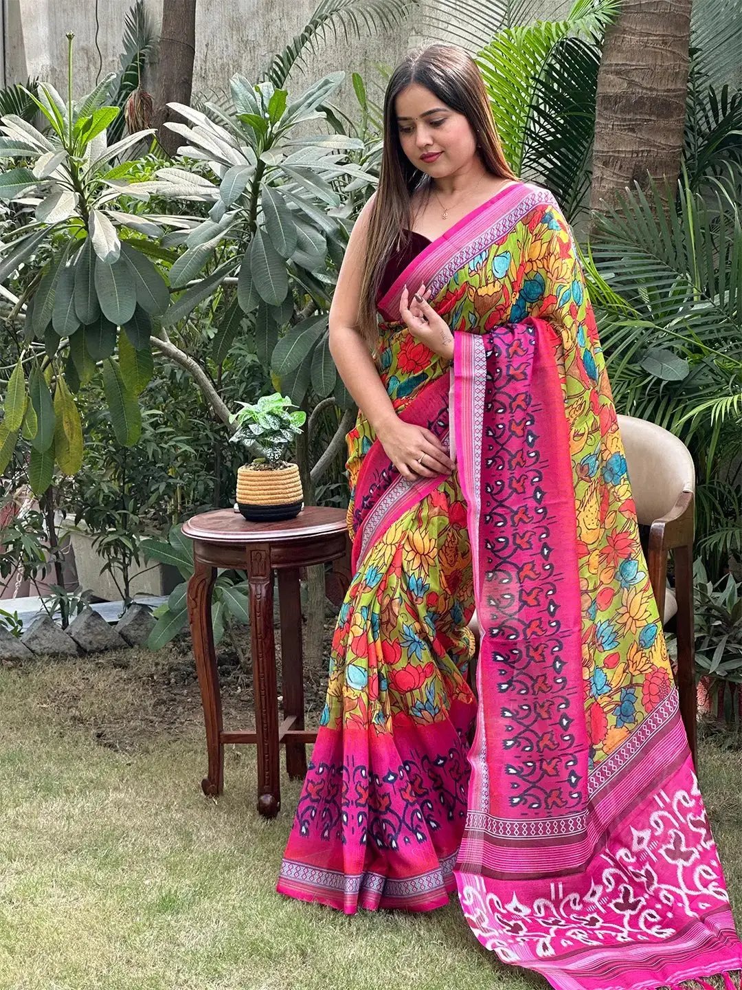 Elegant floral Ikkat saree with pink border, garden setting