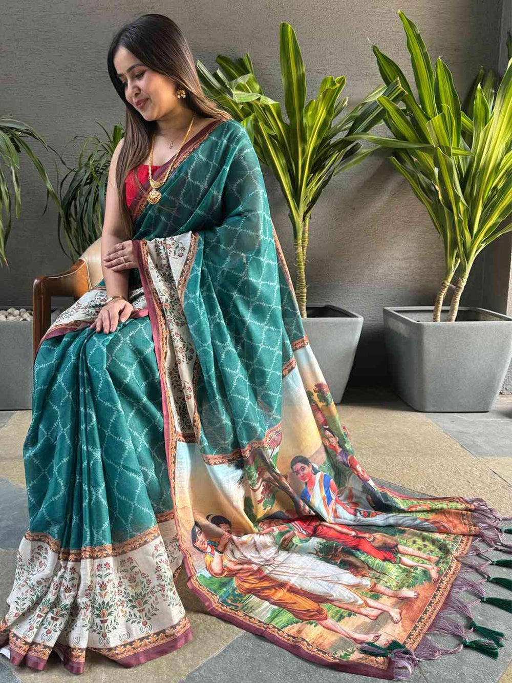 Teal Ikkat saree with kalamkari design, seated view