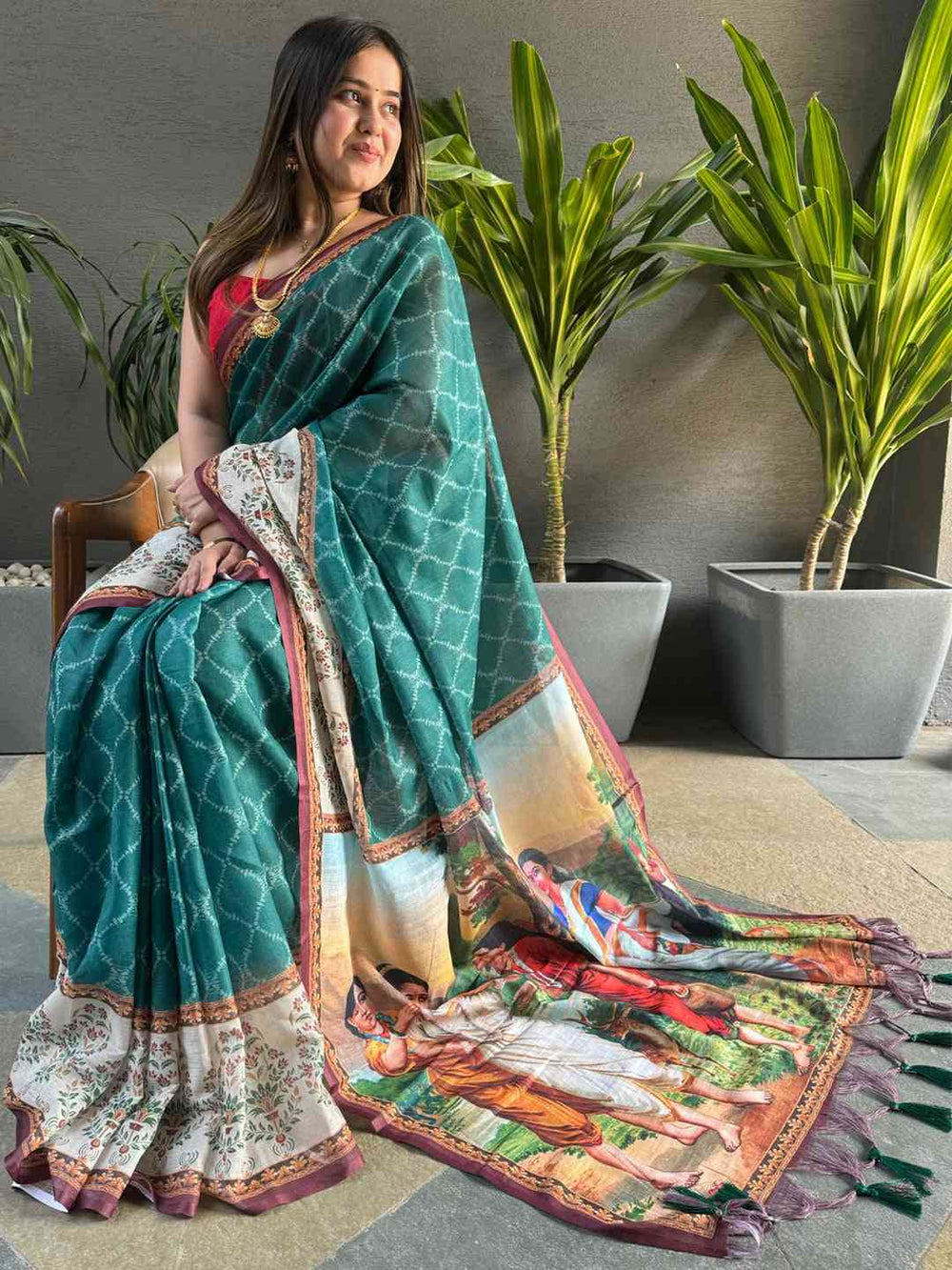 Teal Ikkat saree with kalamkari design, seated view