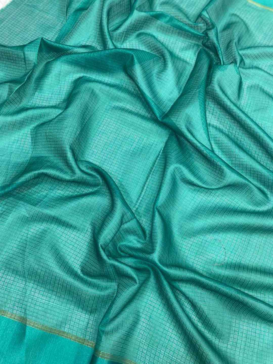 Close-up of sea green satin Kota Doriya fabric with grid pattern