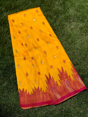 Yellow silk saree with embroidered motifs on grass