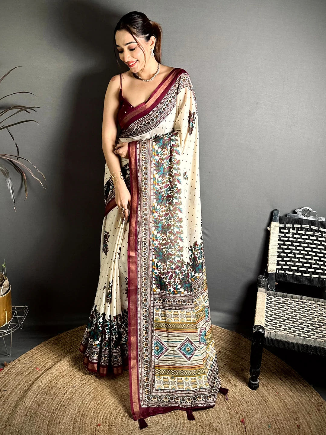Cream mul cotton kalamkari print saree, full front drape on a model standing on a jute rug with tasselled pallu