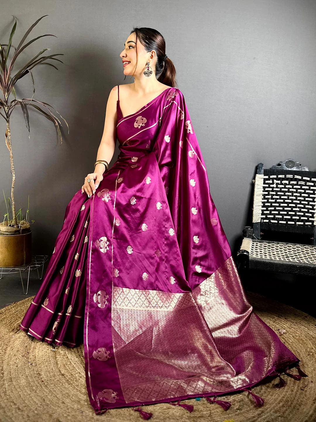 Wine mashru satin silk Garuda zari butta saree, seated pose with the pallu spread out and tassels at the end