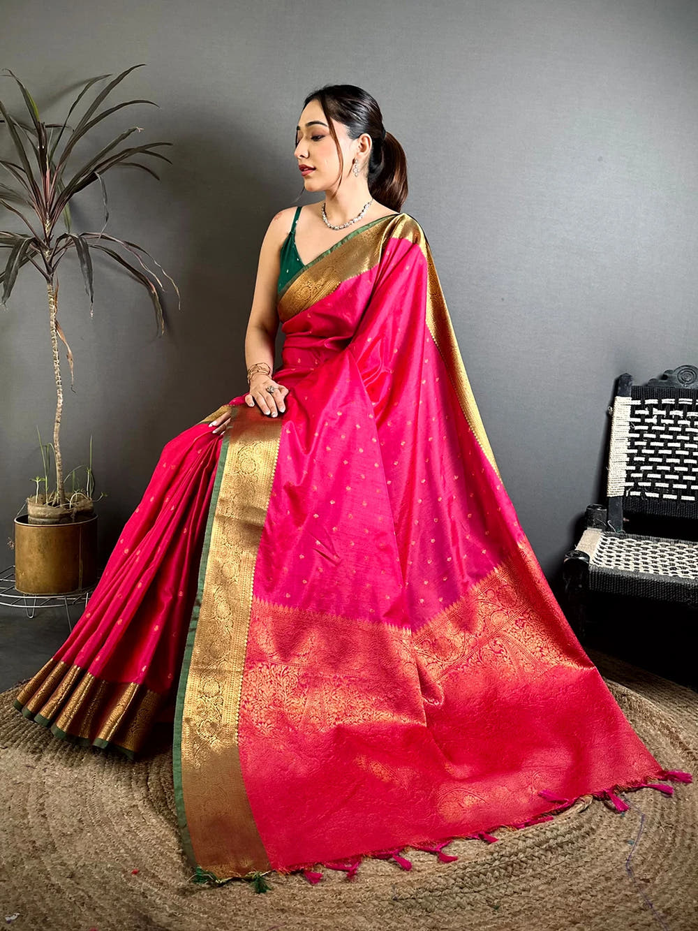 Royal Pink Raw Silk woven buti saree, seated pose on a jute mat showing the detailed woven pallu and border