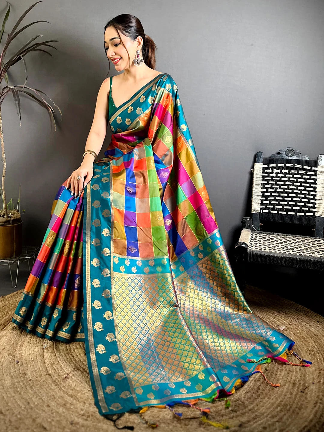 Teal multi colour soft silk Pallampazam-style chex saree, seated pose showing the rich pallu and tasselled end