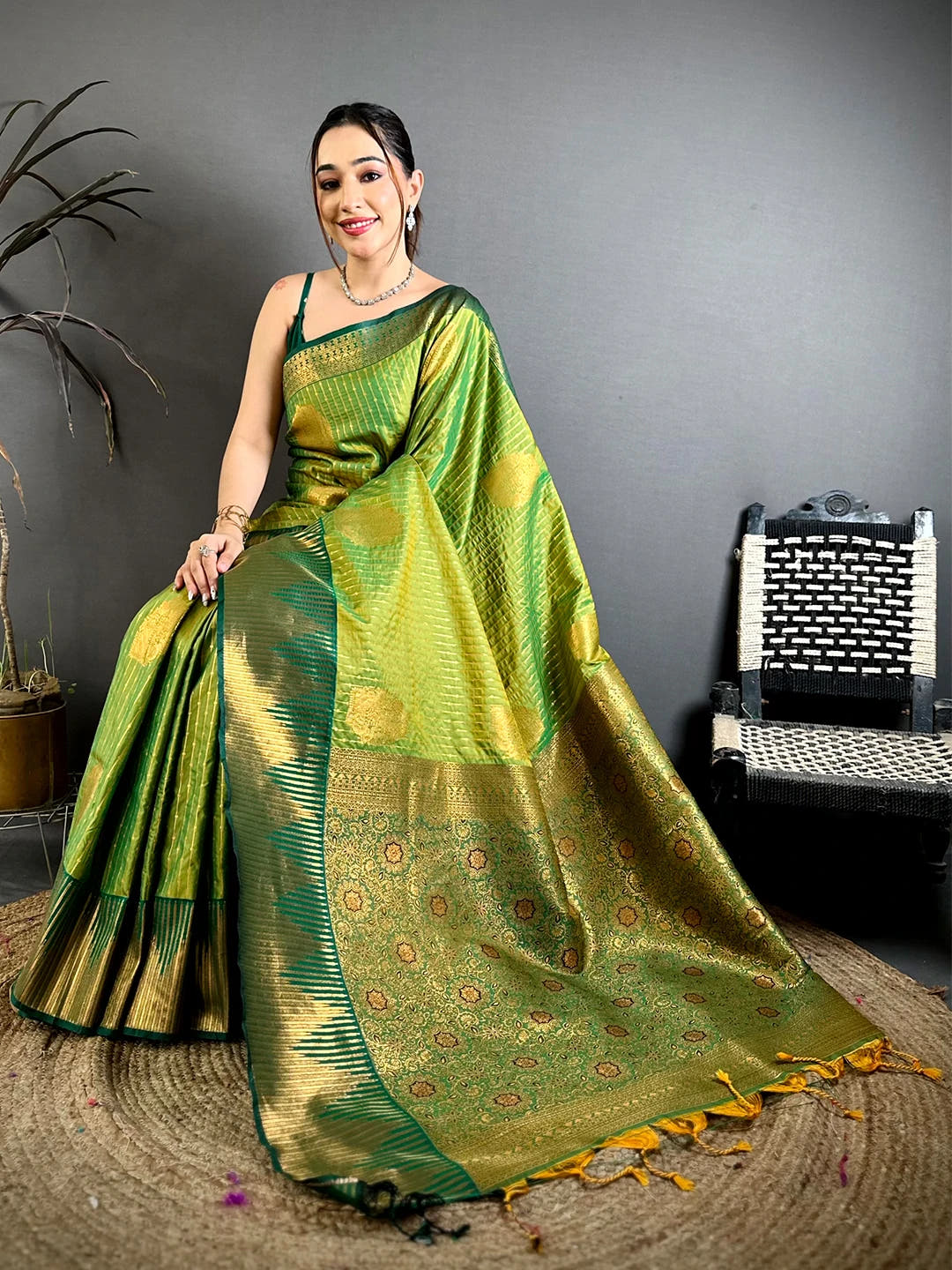 Green Soft Silk Zari Weave Saree, seated model with woven zari pallu, stripe work body and tassels