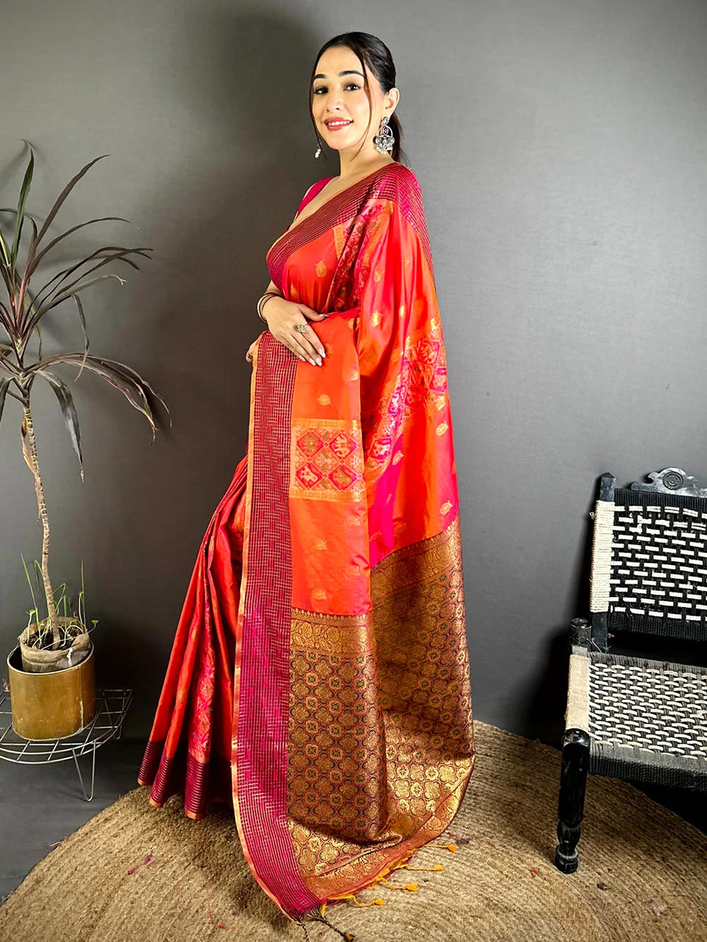 Red-orange Soft Silk Ikkat Pochampally saree, side view showing the drape, buti motifs and gold zari-style pallu