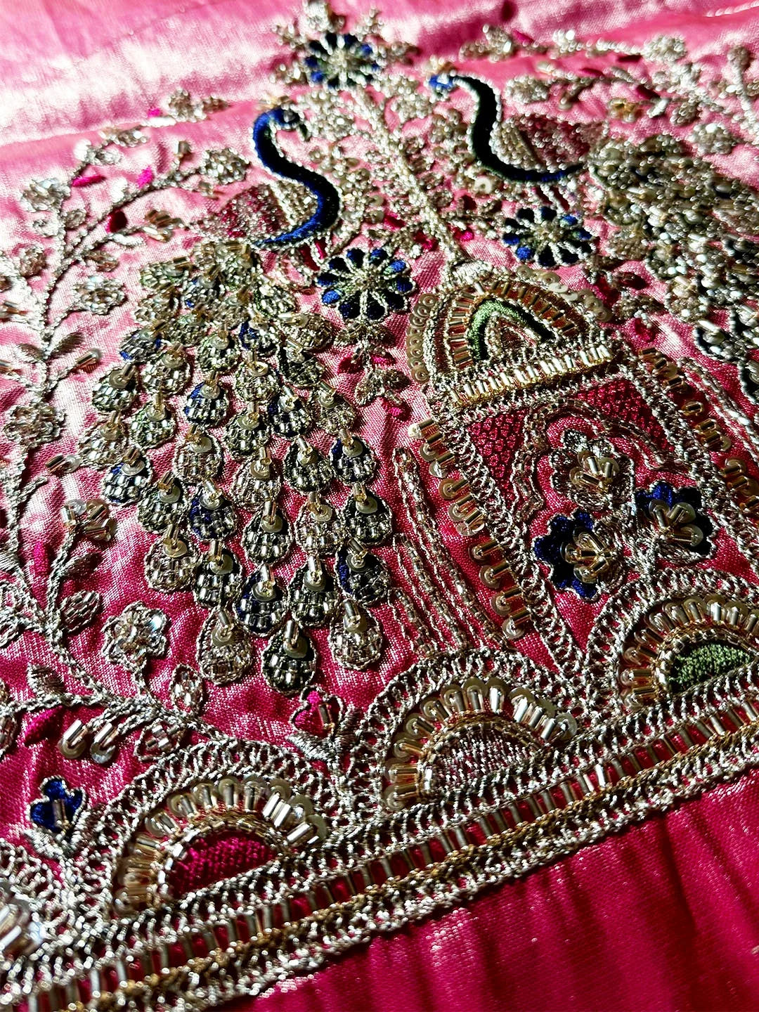 Aqua organza tissue Paithani-style minakari saree, close-up of blue peacock necks and beadwork on pink blouse piece