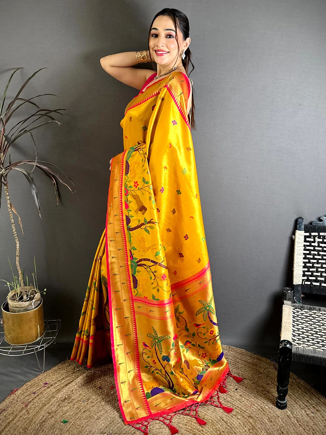 Mustard Soft Silk Paithani-style woven saree, side view on model showing floral body motifs and pink contrast border