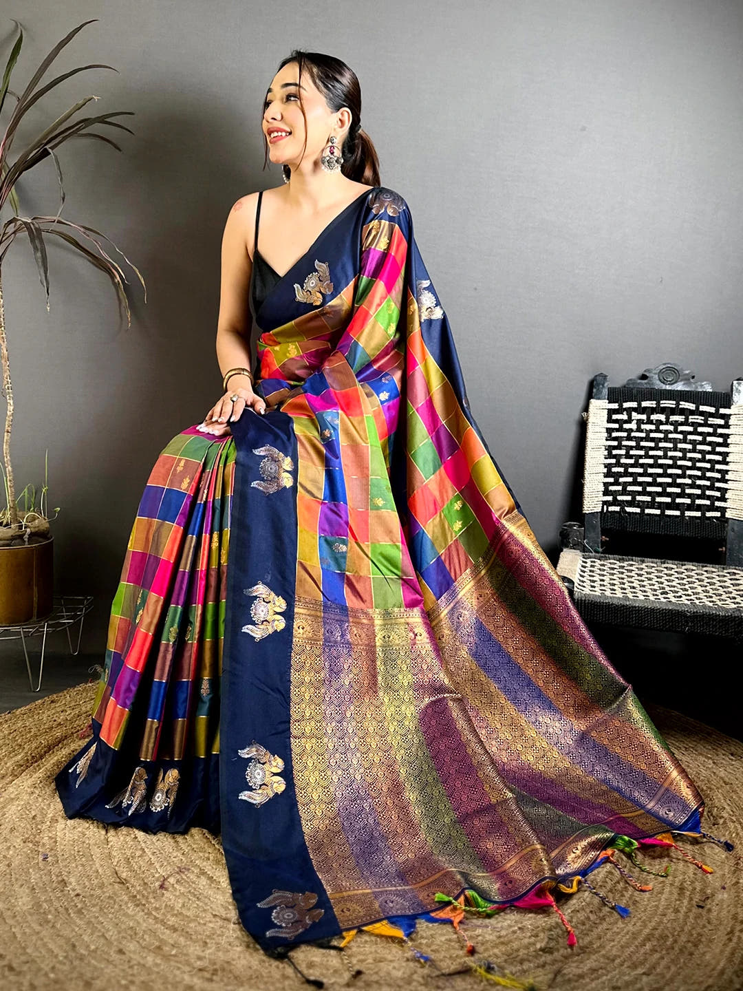 Navy multi colour soft silk checks saree, seated pose showing the zari-style pallu and the motifs on the body
