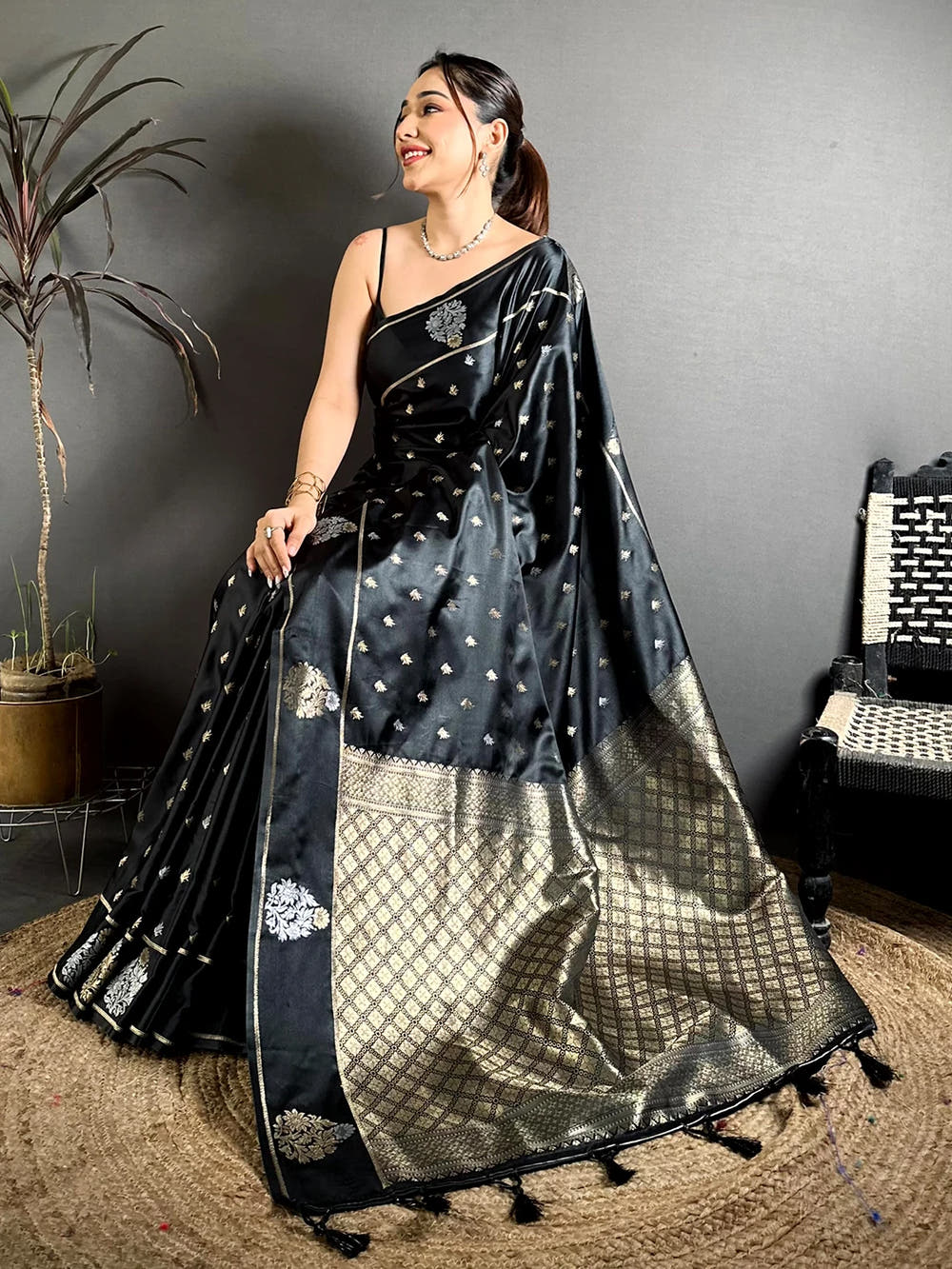 Black Mashru Silk Zari Butta Saree, pallu with checked zari weave and tassels spread out on a jute mat