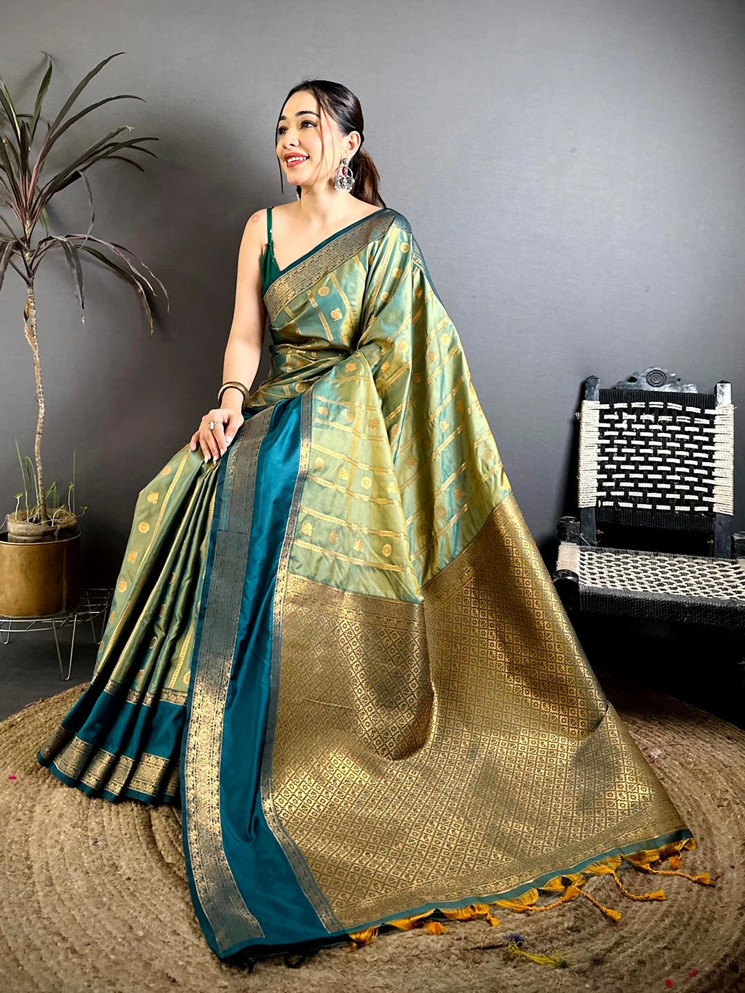 Pista green Banarasi silk zari butta saree, seated pose showing the woven pallu and tassel ends on jute mat