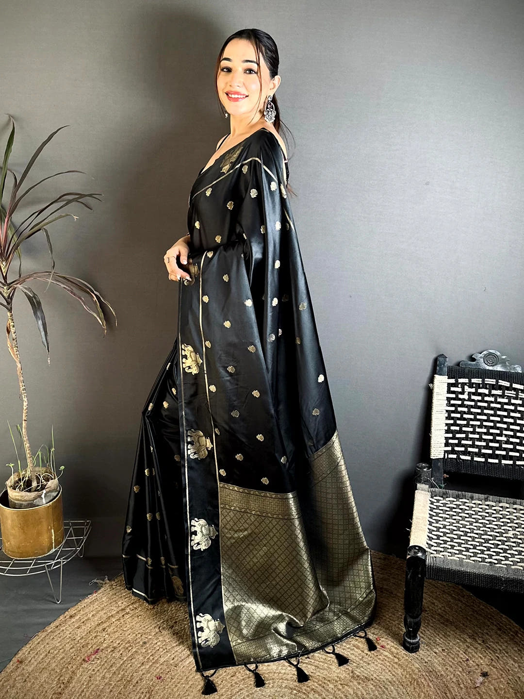 Black Mashru Satin Silk elephant zari butta saree, side view of the body butta and the broad woven pallu on the floor