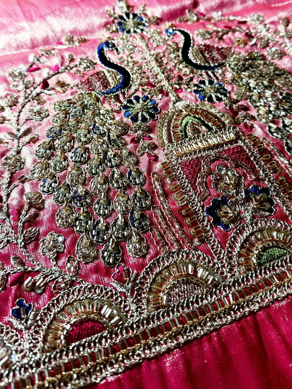Pink blouse piece for pista green organza tissue Paithani minakari saree, close-up of sequin and zari peacock motif