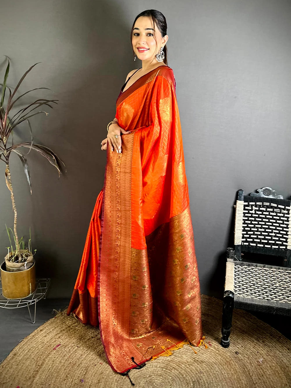 Orange Soft Silk zari check saree, side view showing the pallu drape and tassel ends on a jute rug
