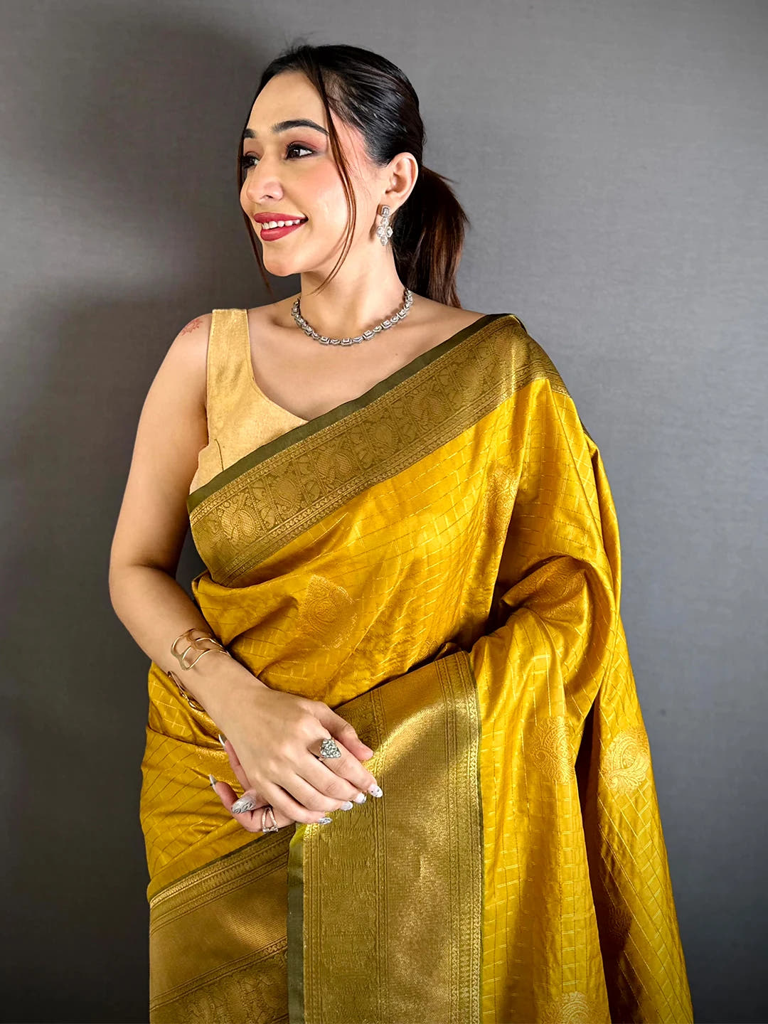 mustard silk checked zari saree, front drape on a model with olive-green border and blouse piece