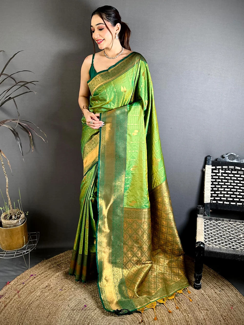 Green soft silk kanchi pattu-style saree, full standing view on a model showing the broad gold pallu with tassels
