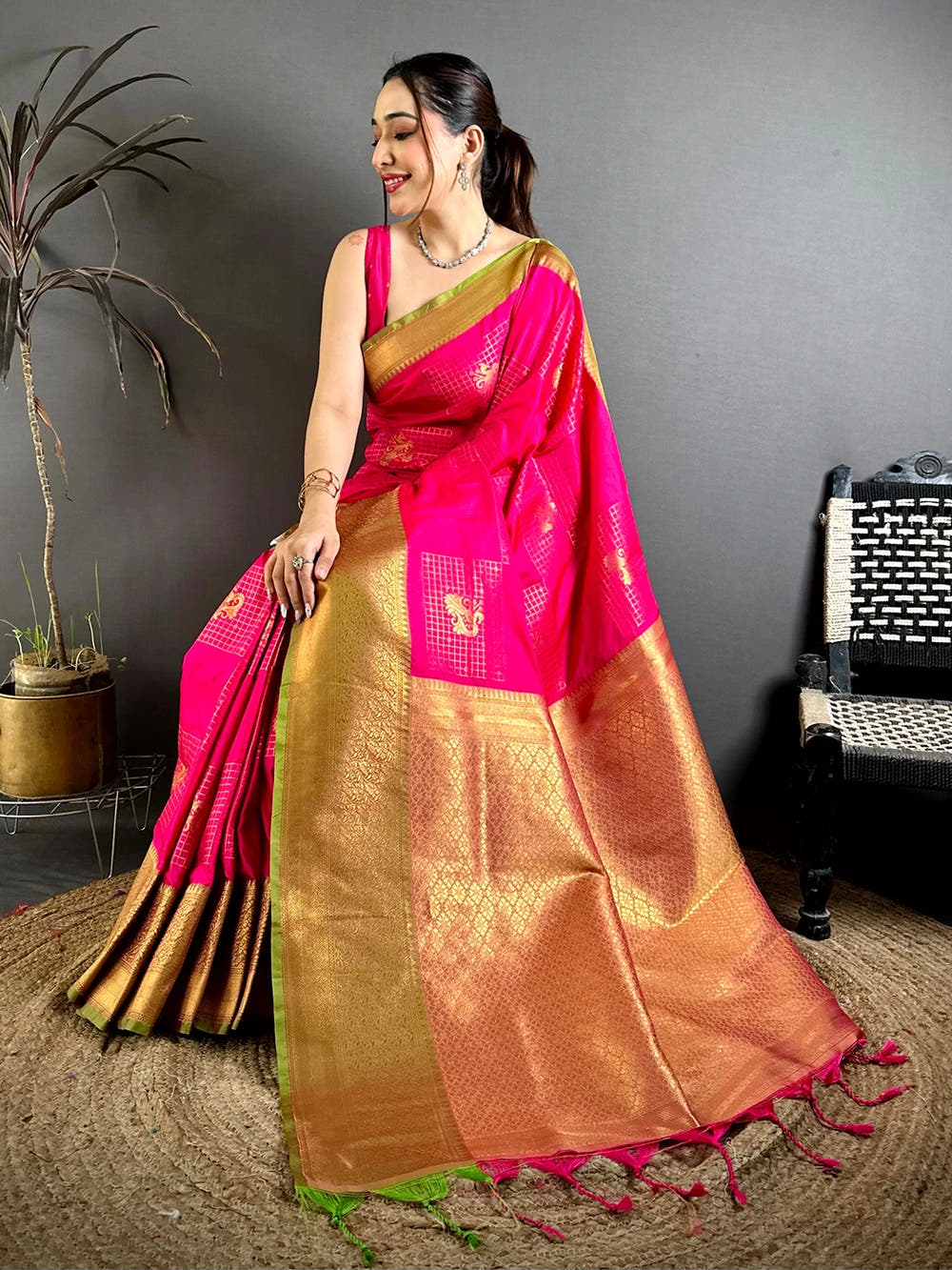 Pink Soft Silk Zari Butti saree, close view of the zari-woven pallu with pink tassels and thin green edge on a model