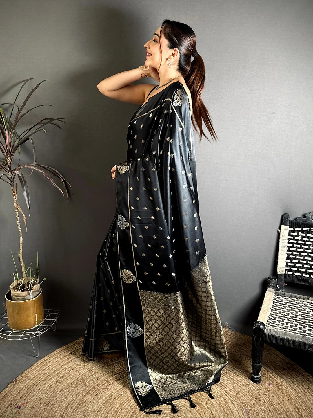 Black Mashru Silk Zari Butta Saree, side view on a model showing the zari border with thin gold lines along the drape