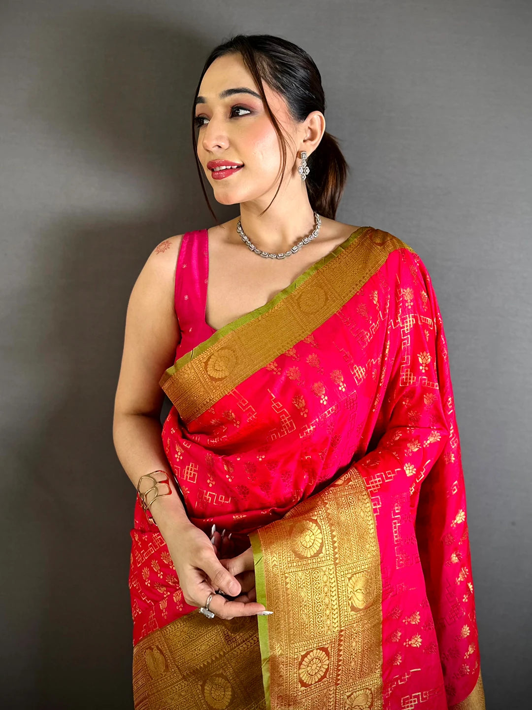Pink soft silk floral zari butti saree, front drape on model with gold zari pallu and green-edged border