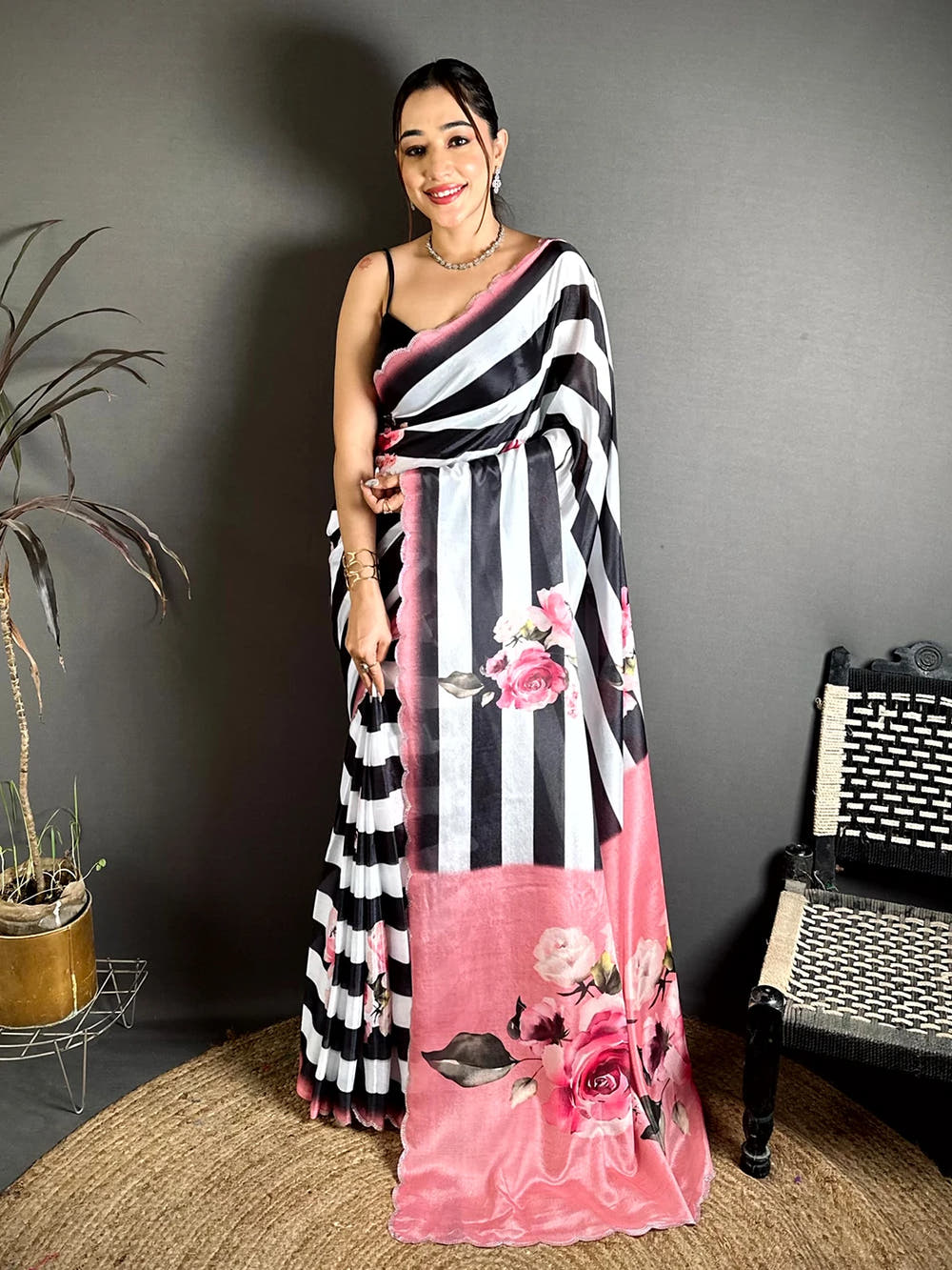 Black and white Soft Chinnon stripe print saree, full front drape on a model with the pink pallu carrying large rose motifs