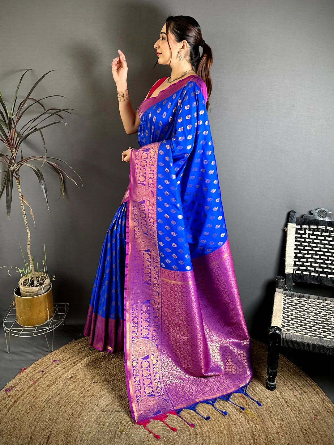Royal blue soft silk zari woven buta saree, side profile of model showing the body drape and zari pallu border