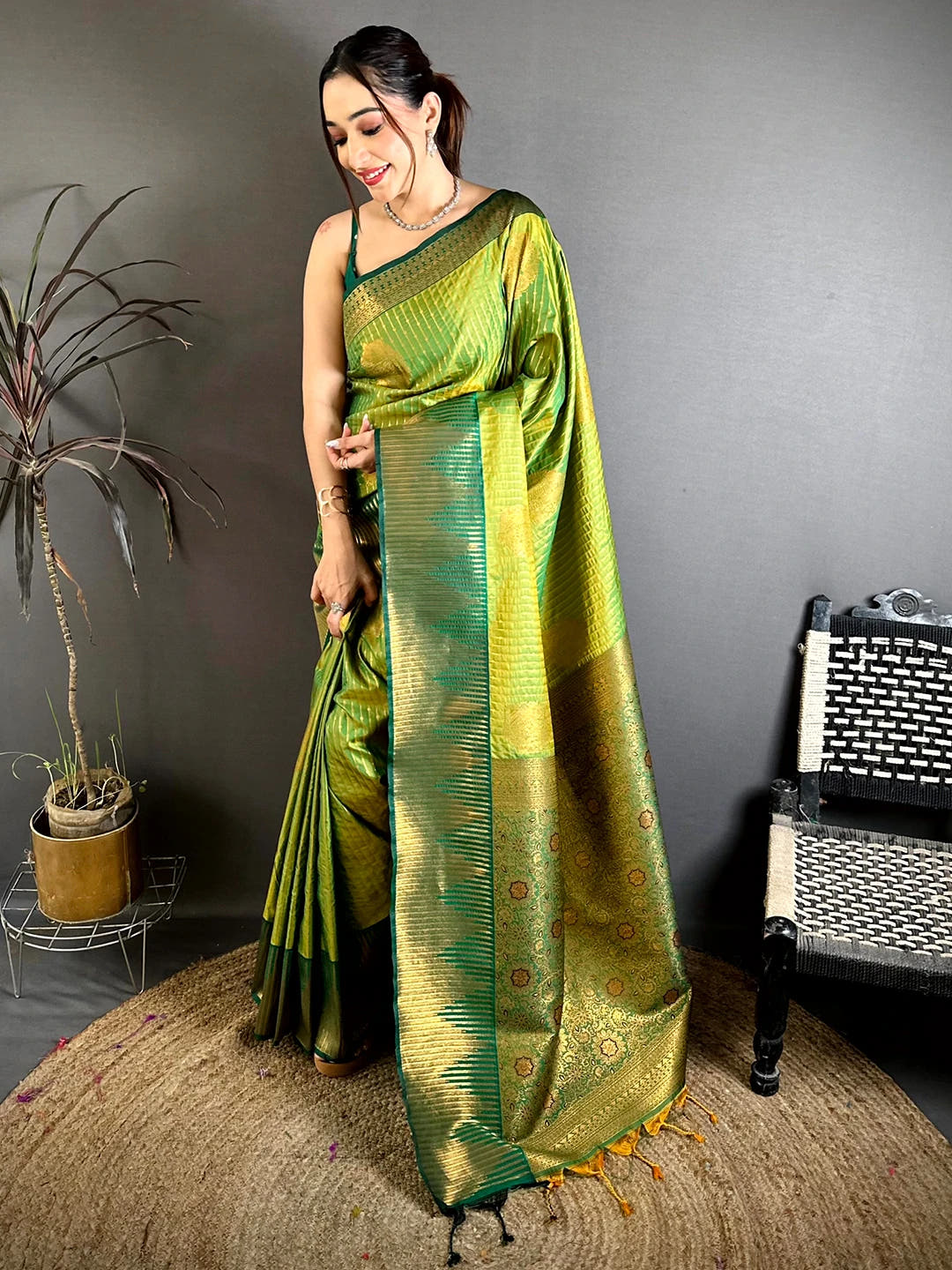 Green Soft Silk Zari Weave Saree, standing model with gold zari pallu and tassels on a jute rug