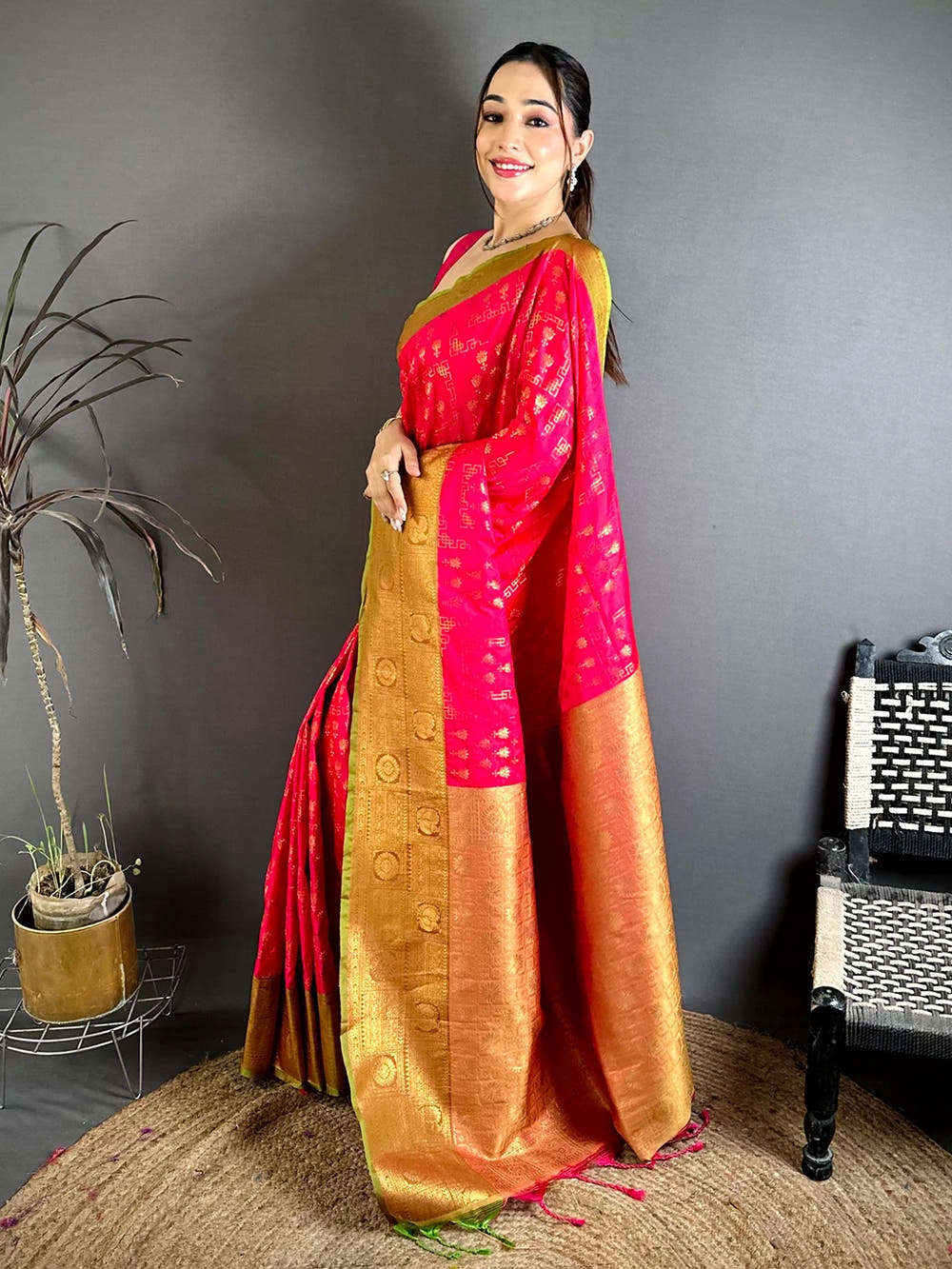 Pink soft silk floral zari butti saree, side view on model showing the pallu drape and thin green border edge