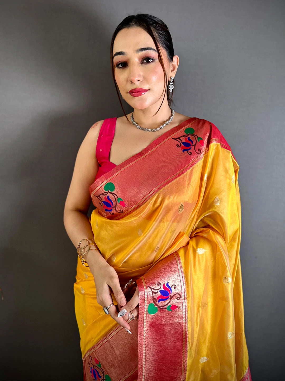 Yellow Organza Tissue Paithani-style saree, model front view showing the red minakari border and pallu draped over her arm