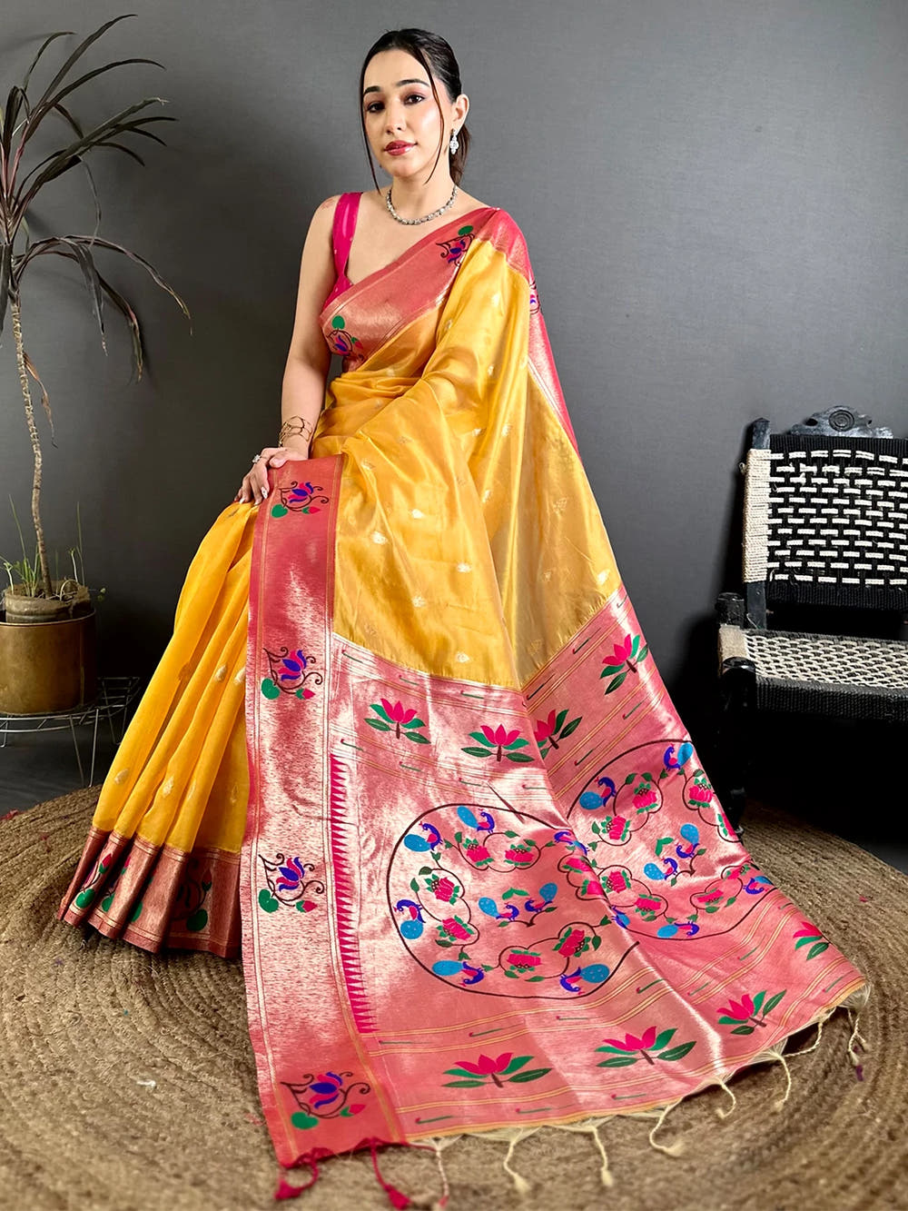 Yellow Organza Tissue Paithani-style saree, pallu with peacock and lotus minakari motifs and tassels spread across the drape